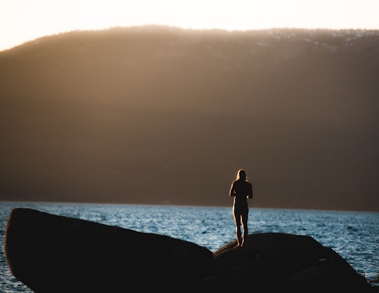 person standing on gray stone near body of water in Lake Tahoe United States