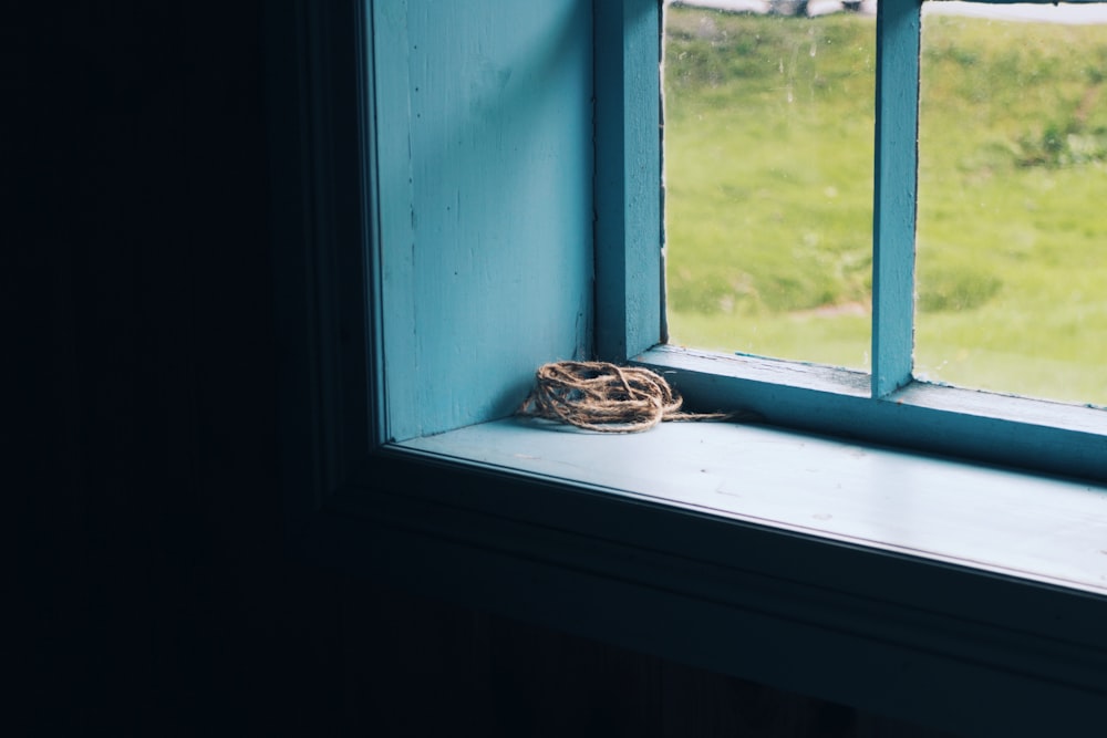 rolled brown string on top of window