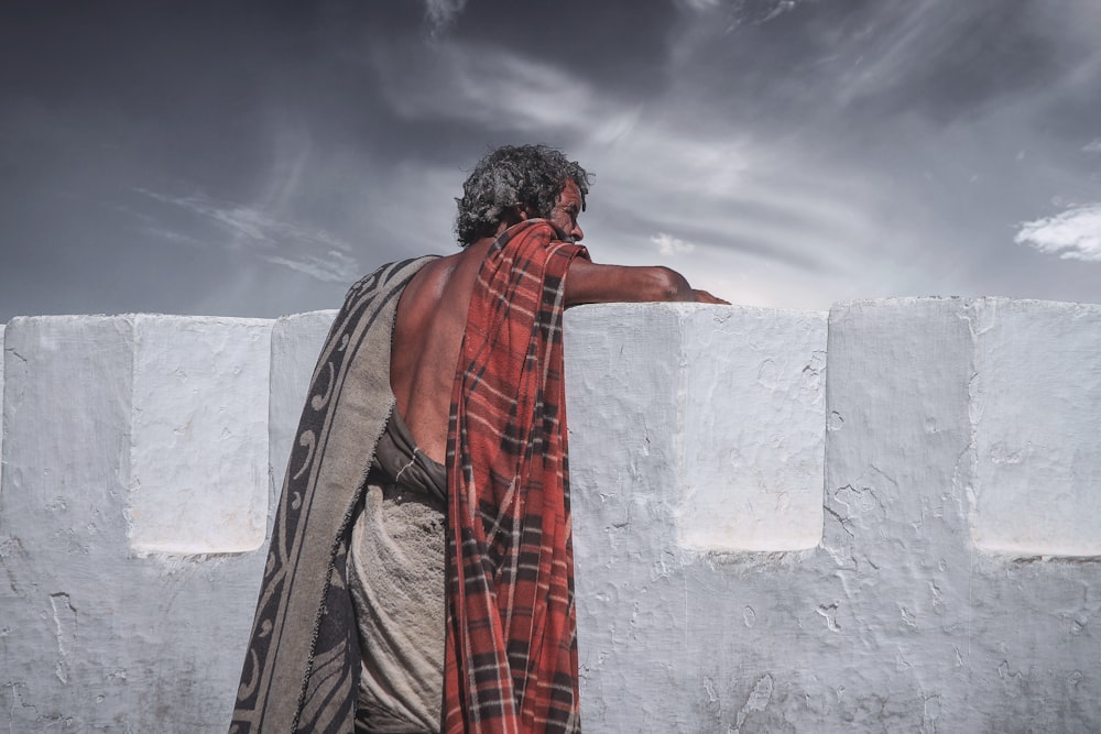 man against concrete wall looking afar