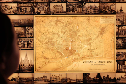 Un antiguo mapa de la ciudad de Barcelona con fotografías de edificios de fondo