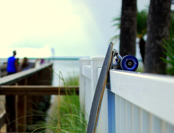 A sleek professional street skateboard resting on an urban sidewalk with graffiti walls in the background.