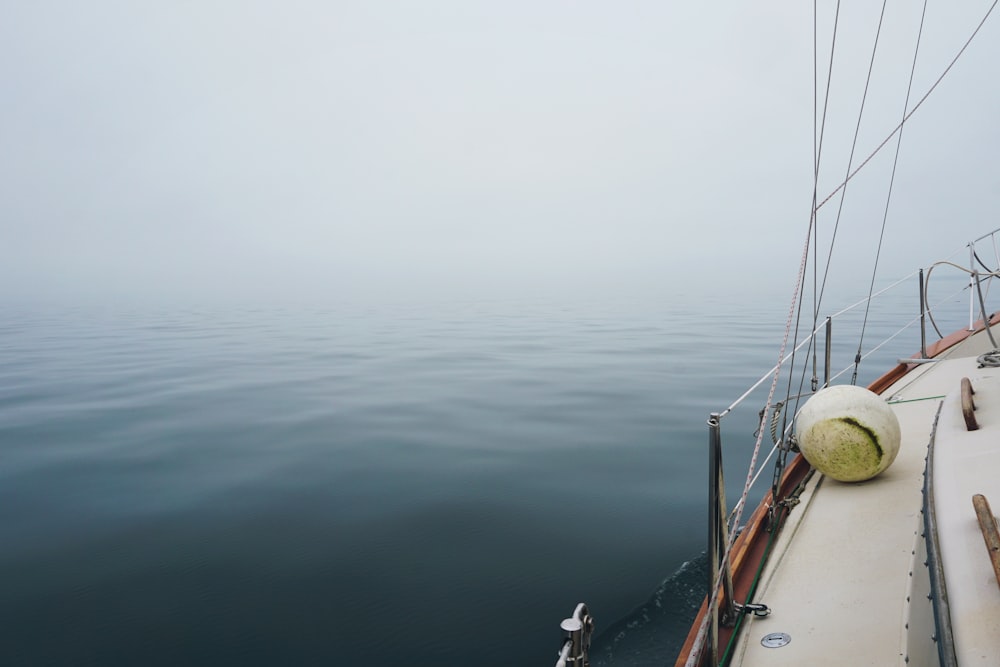 white sailboat on ocean with fog