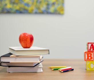 red apple fruit on four pyle books