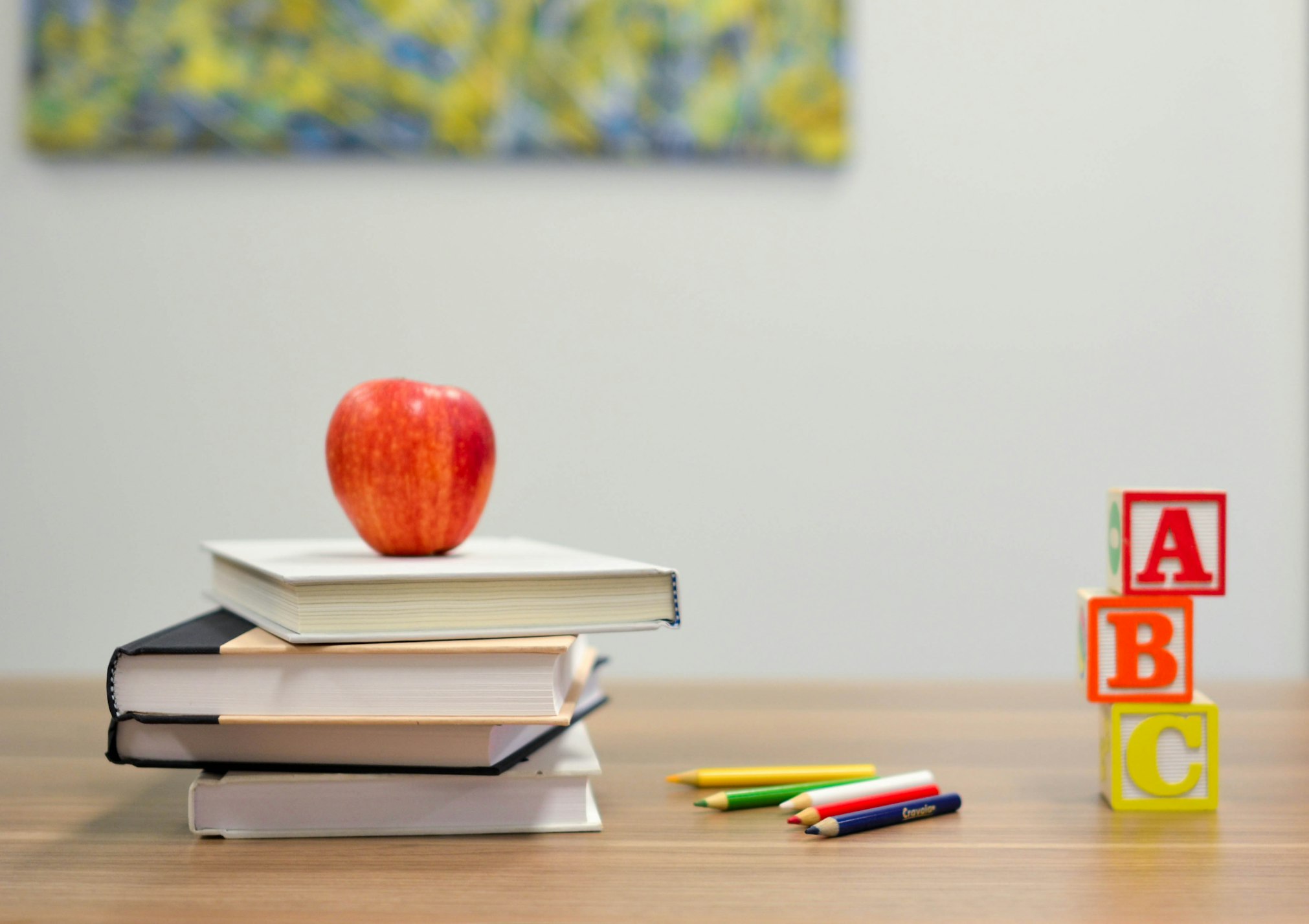 school books, blocks and apple on a desk
