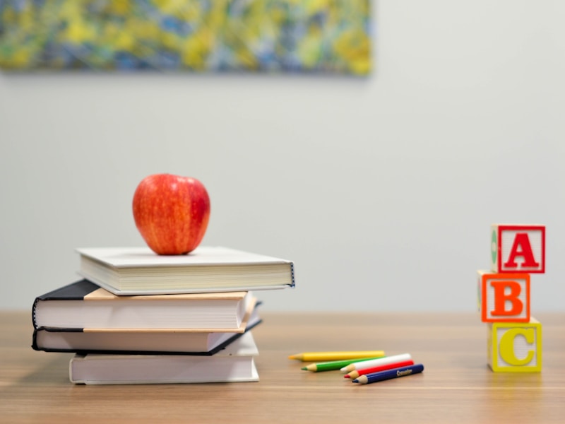 Classroom desk with school supplies and apple