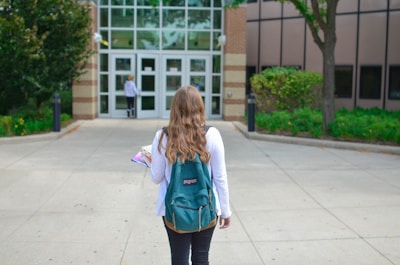 A student exploring a university campus with a backpack and books.