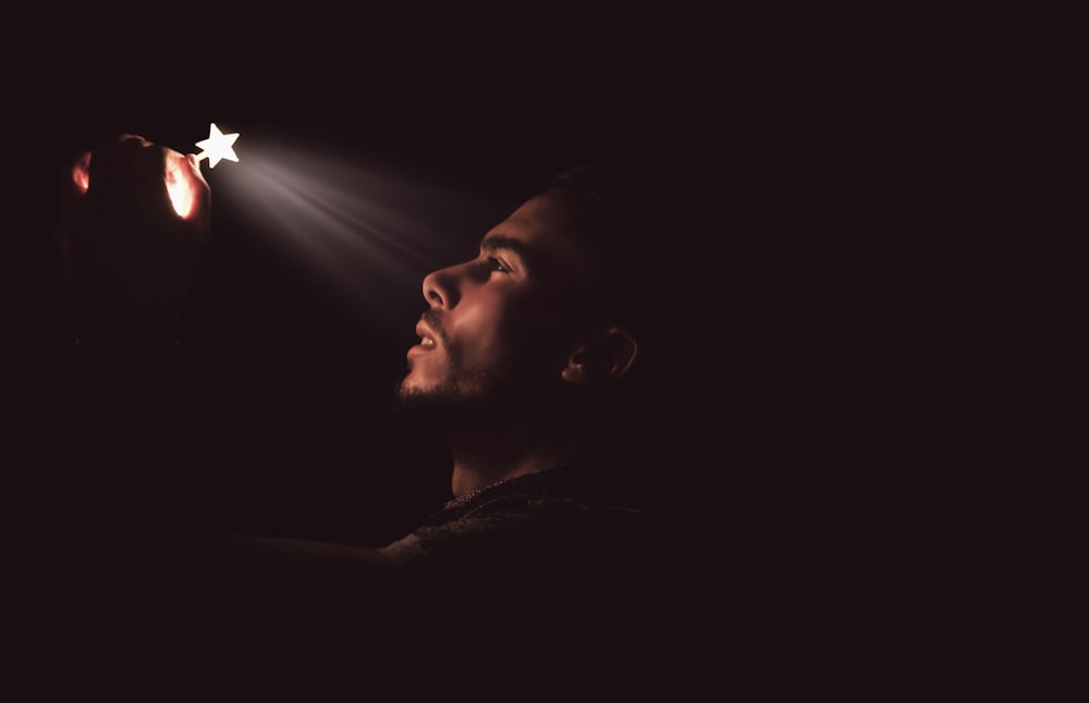 homem segurando a estrela branca do diodo emissor de luz