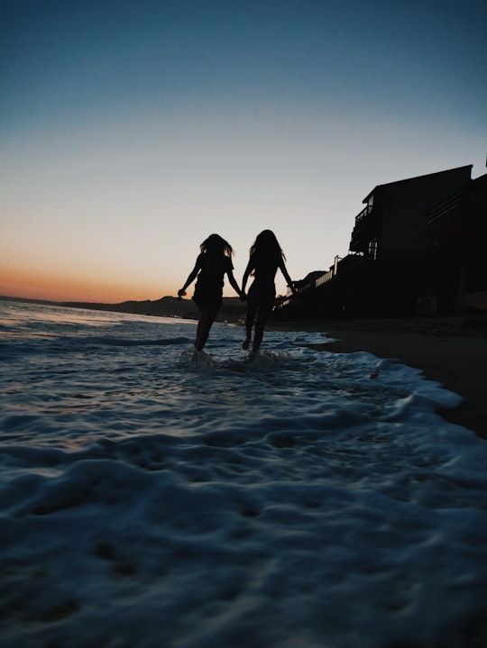 silhouette of two women running across seashore in Malibu United States