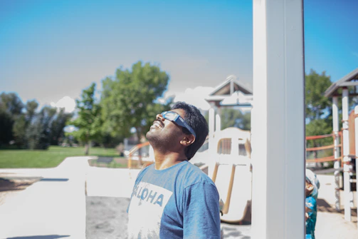 A person wearing eclipse glasses looking at the sky