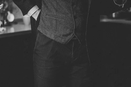 Black and white close-up of a tailored garment showcasing fine stitching and minimalist design.