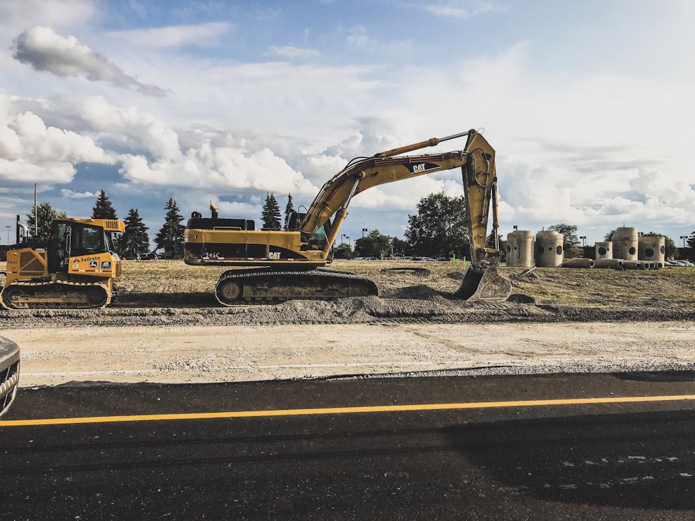 yellow Caterpillar excavator digging up dirt