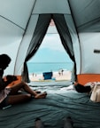 Interior of spacious Ocean Tent featuring comfortable bedding and sea-view windows open to gentle ocean breeze.