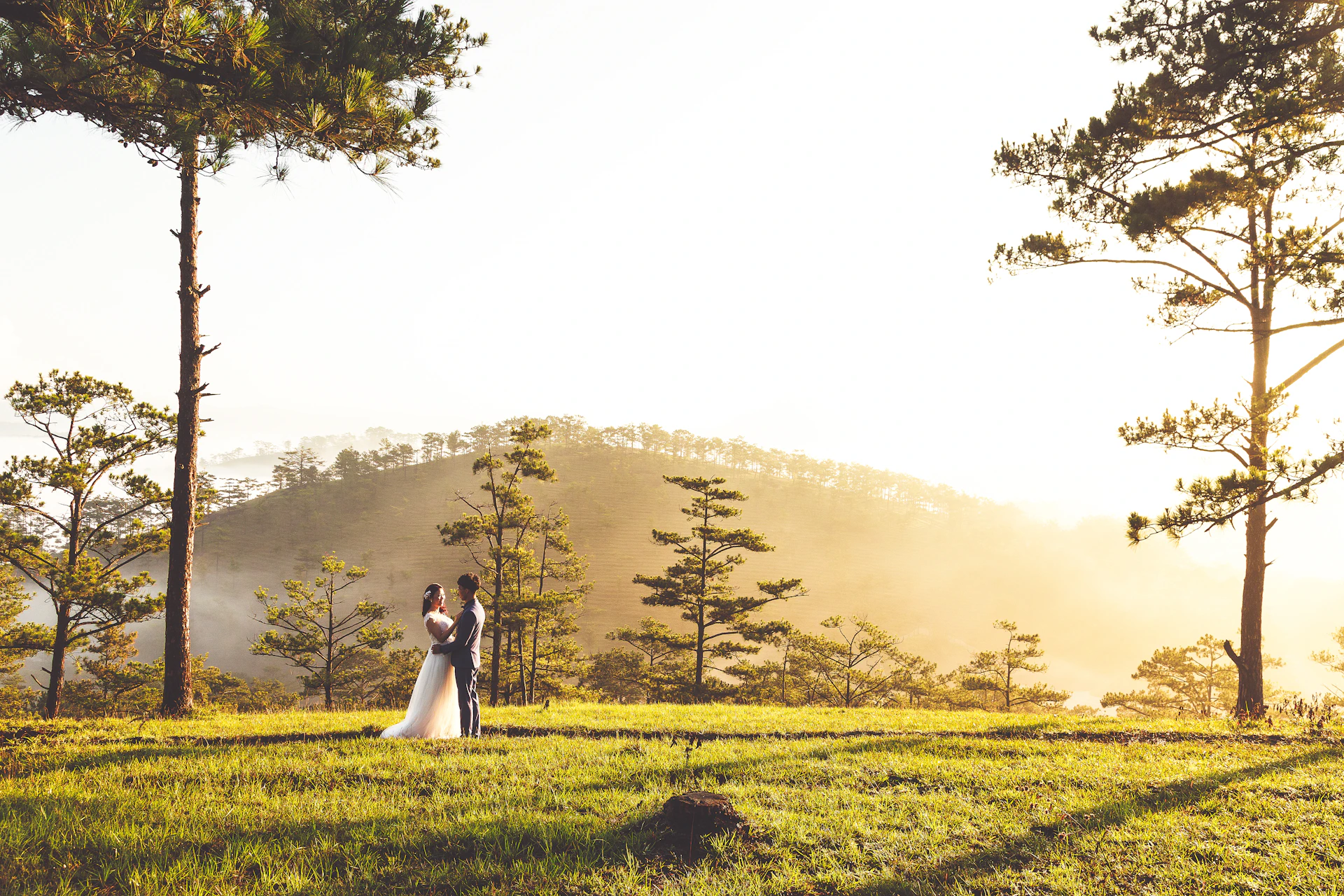 A joyful couple enjoying a peaceful moment on a hilltop during their honeymoon trip.