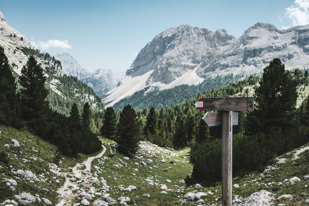 Mountain landscape with signs pointing toward a rocky hiking path