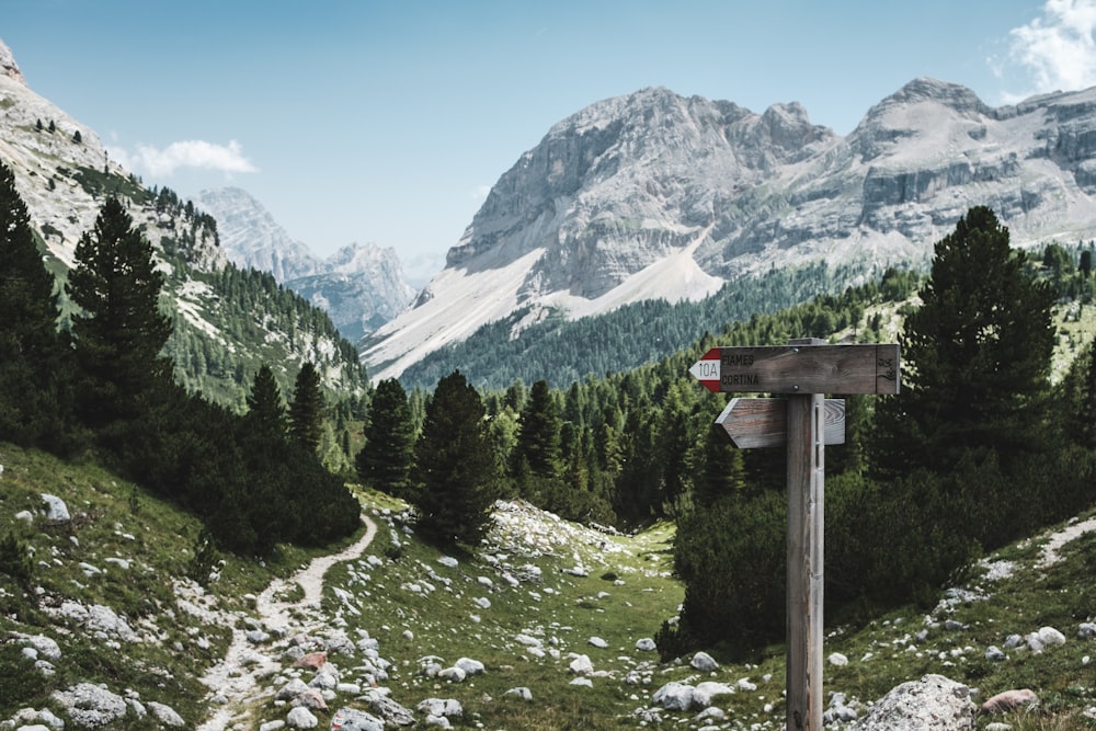 Paysage de montagne avec des panneaux indiquant un chemin de randonnée rocheux