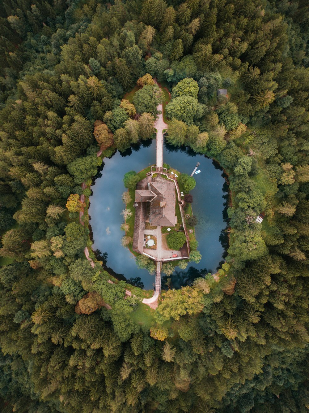 aerial photography of building surrounded with body of water and trees during daytime