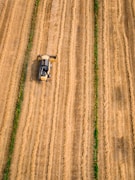 aerial photography of yellow cultivator on brown field