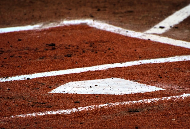 softball, a baseball field with a white line on it