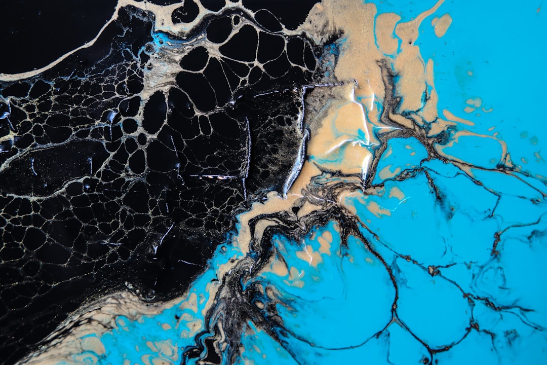 blue and black abstract painting, I’ve been experimenting with mixing acrylic paints and different mediums to see how they blend together. This is a macro shot of gold, teal, and black paints poured onto a gessoed and repurposed tile.<p></figure>Each paint was individually mixed with glue and isopropyl alcohol to change the density, rate of drying, and the way they interact.