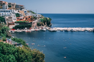 A scenic coastal village in Greece with a family strolling along the harbor.