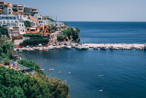 A scenic coastal village in Greece with a family strolling along the harbor.