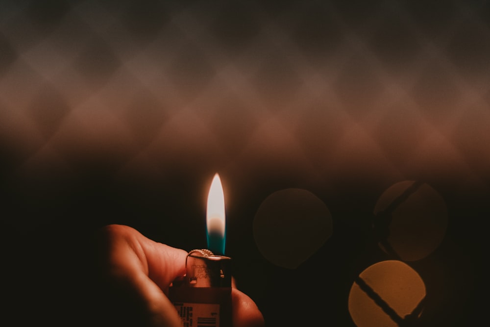 Hand holds a lighter with a blue and yellow flame in the dark; how to pick the best dabs