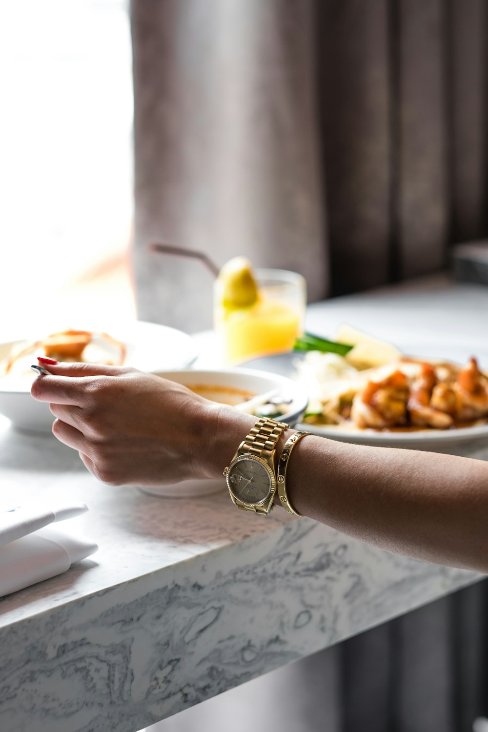 person wearing wath near table with dish filled with foods