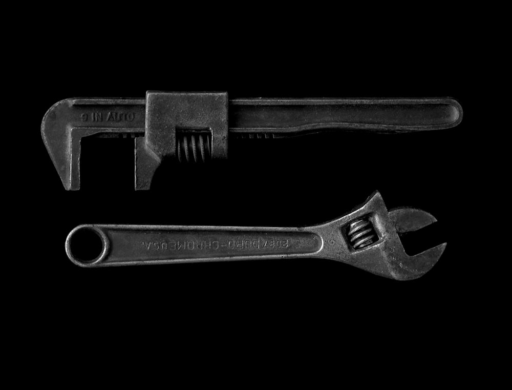 gray adjustable wrench and gray pipe wrench