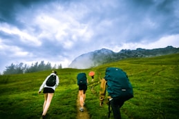 four person hiking on mountain hill during daytime