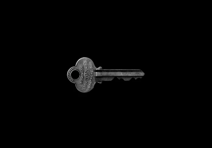 A single metal key against a black background