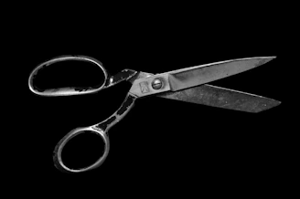 Robust industrial scissors displayed against a minimalist charcoal background highlighting their metallic finish.