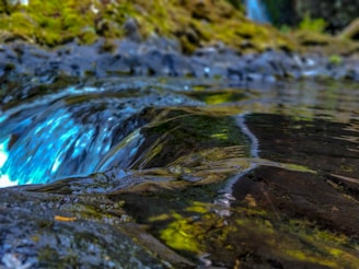 An outdoor scene of a water source with clear blue water, representing purity.