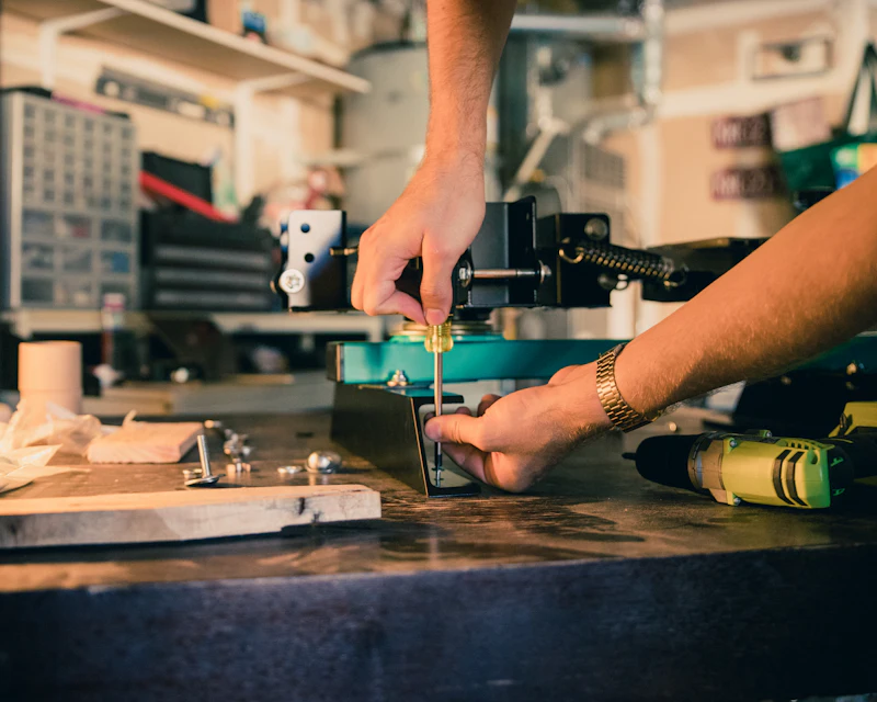 Hand mit Schraubendreher bei der Reparatur eines Geräts