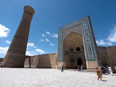 blue and brown building with blue and brown archway under blue sky chimney teams background