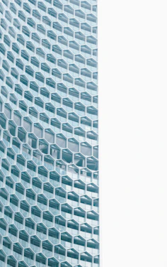 A sleek modern office space with hexagonal patterned glass walls reflecting calm professionalism.