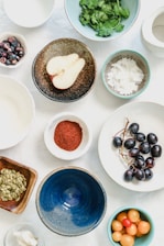 An overhead shot of fruits, seeds and spices in bowls
