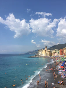 A vibrant coastal town with tourists enjoying local culture under a bright blue sky.
