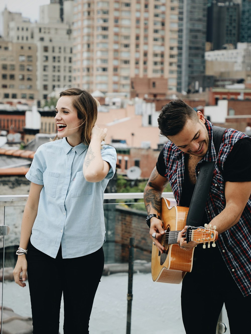 man playing guitar beside singing woman