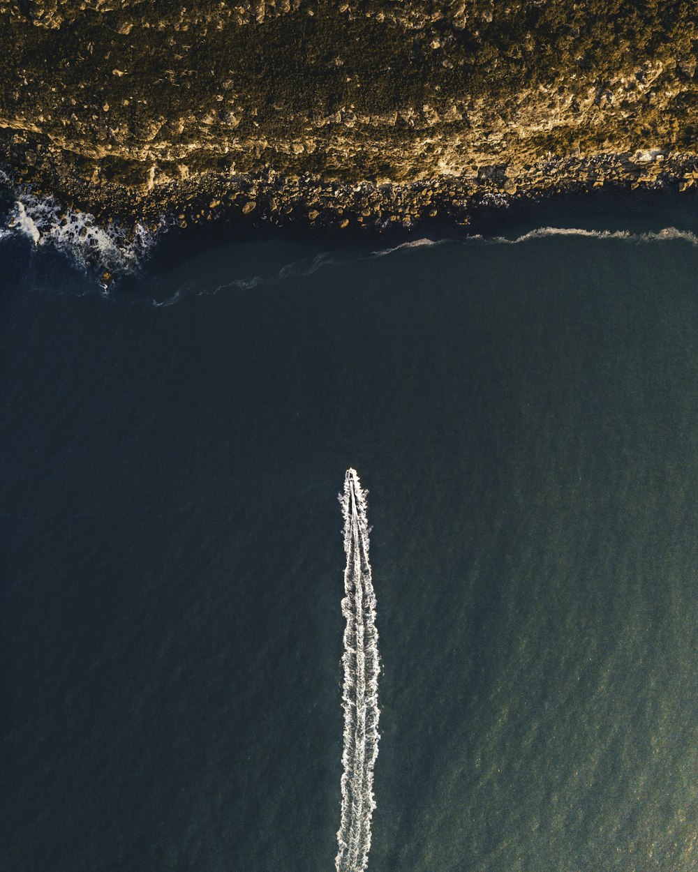 bird's eye view photography of speedboat towards coastline