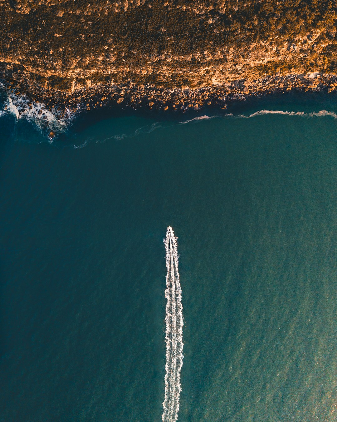 bird's eye view photography of speedboat towards coastline