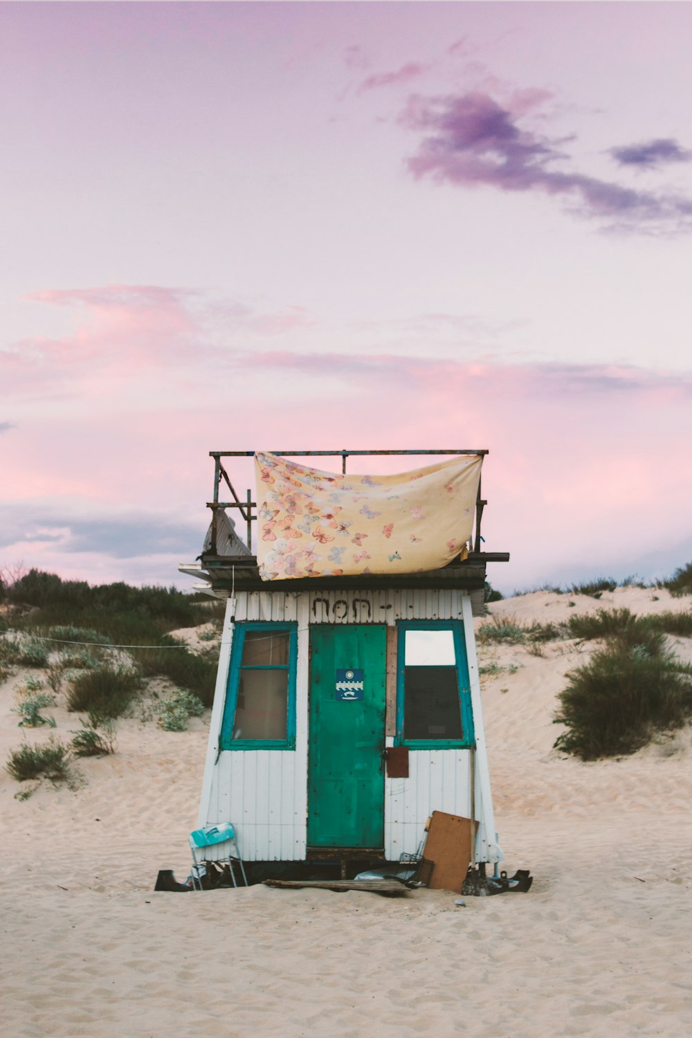 white and green shed on sand
