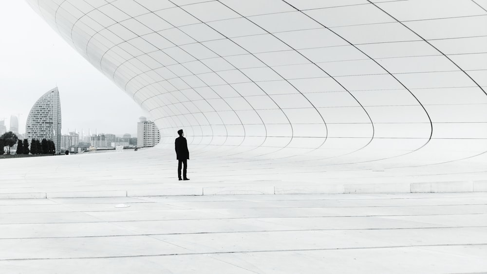 person standing in a middle of white plate field