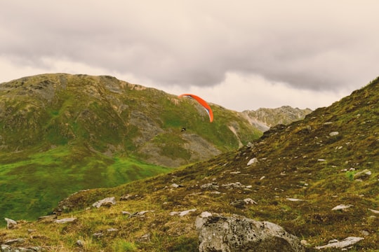 photo of person sky diving in between mountains in Alaska United States