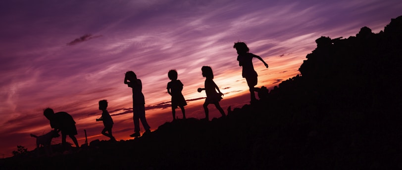 silhouette of children's running on hill