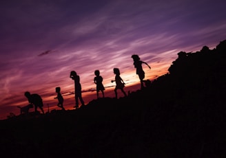 silhouette of children's running on hill