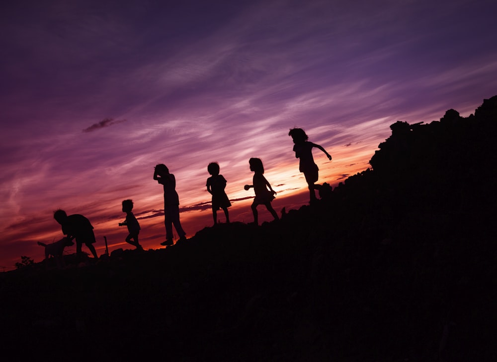 Silueta de los niños corriendo en la colina