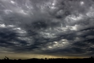 A dramatic sky filled with swirling clouds over a battlefield.
