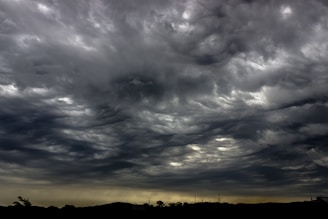 A dramatic sky filled with swirling clouds over a battlefield.