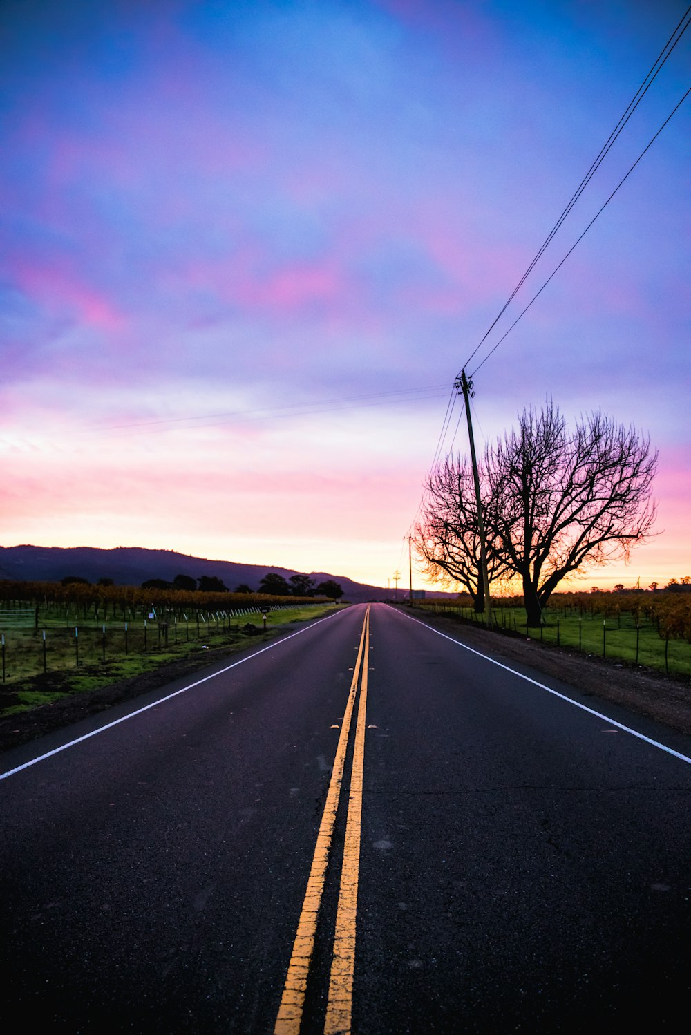 empty paved road under blue sky