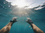 Close-up of hands touching the finish line buoy under bright sunlight